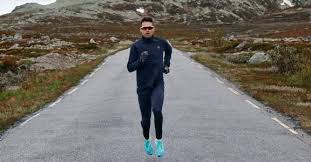 Homme qui court sur une piste d'asphalte